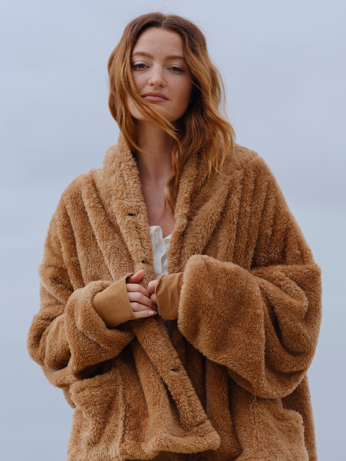 Model wearing the Camel Brown Crop Papàsweater on the beach