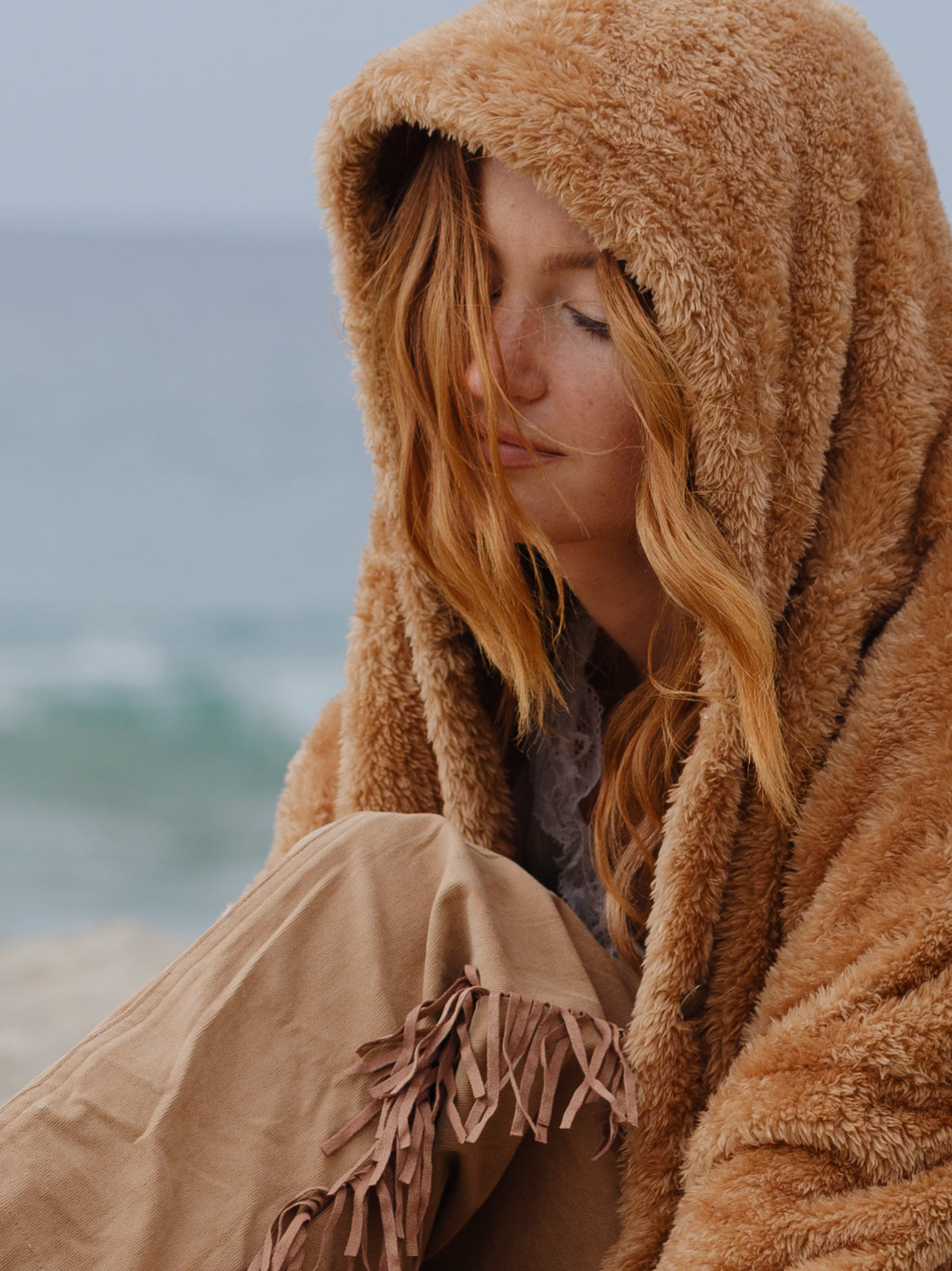 Model wearing the Camel Brown Crop Papàsweater on the beach
