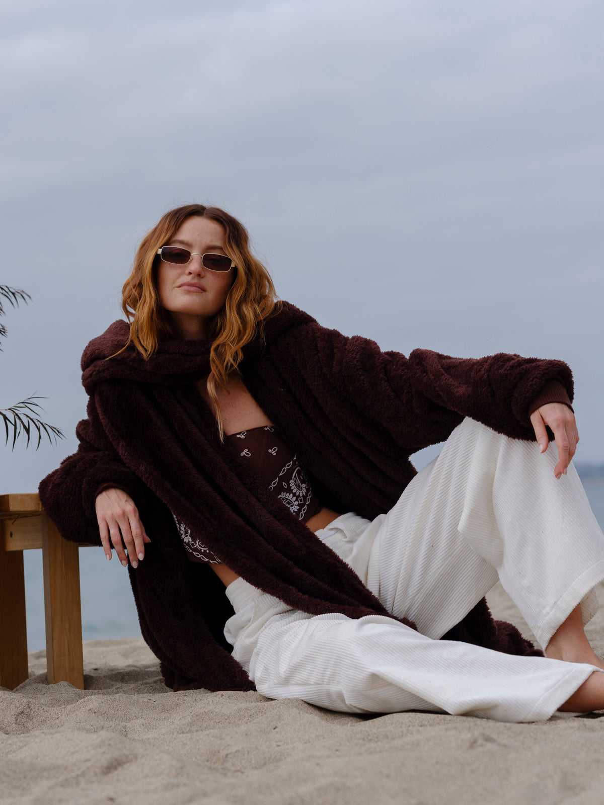 Model wearing the Dark Chocolate Mid Papàsweater on the beach