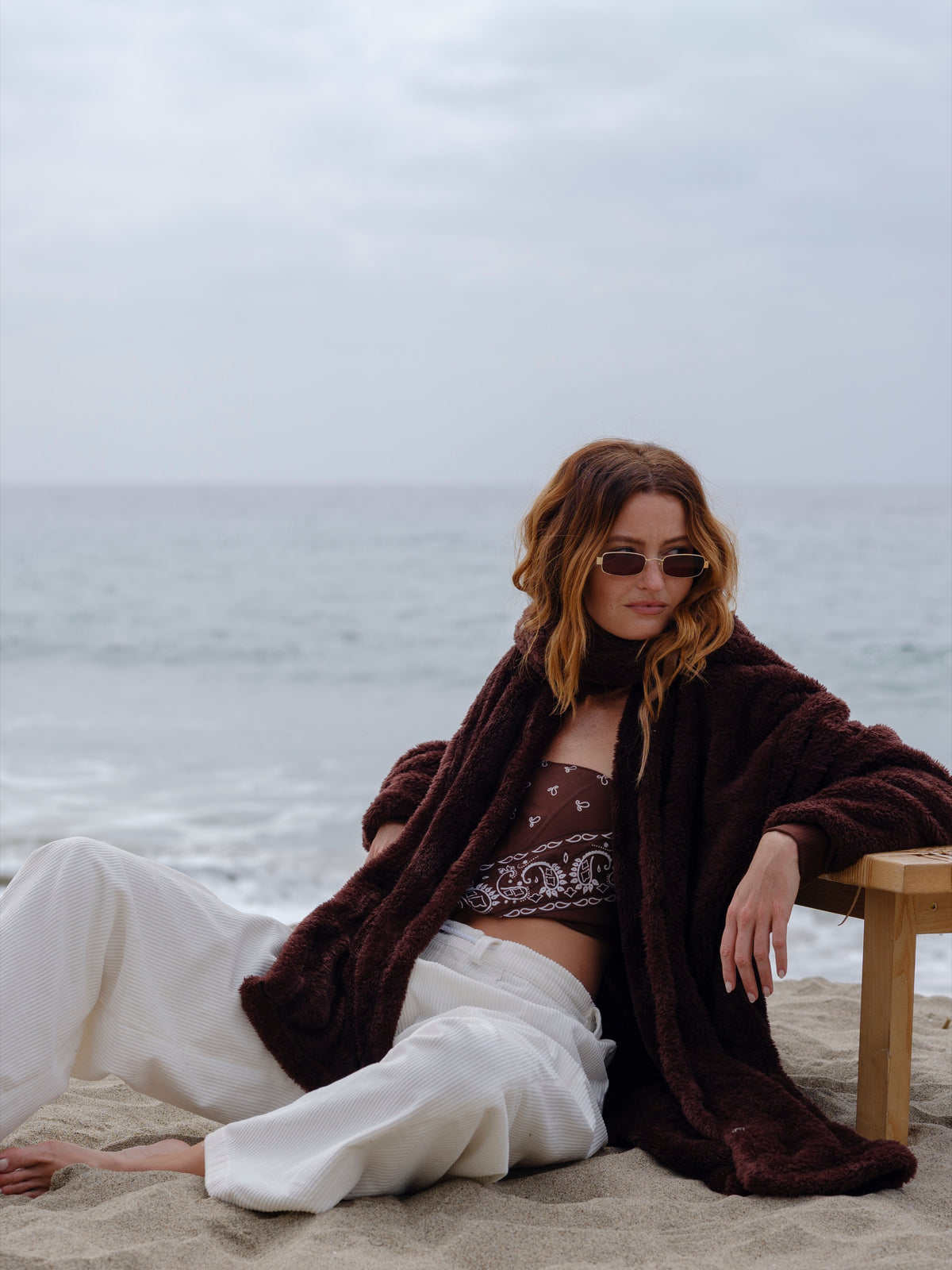 Model wearing the Dark Chocolate Mid Papàsweater on the beach