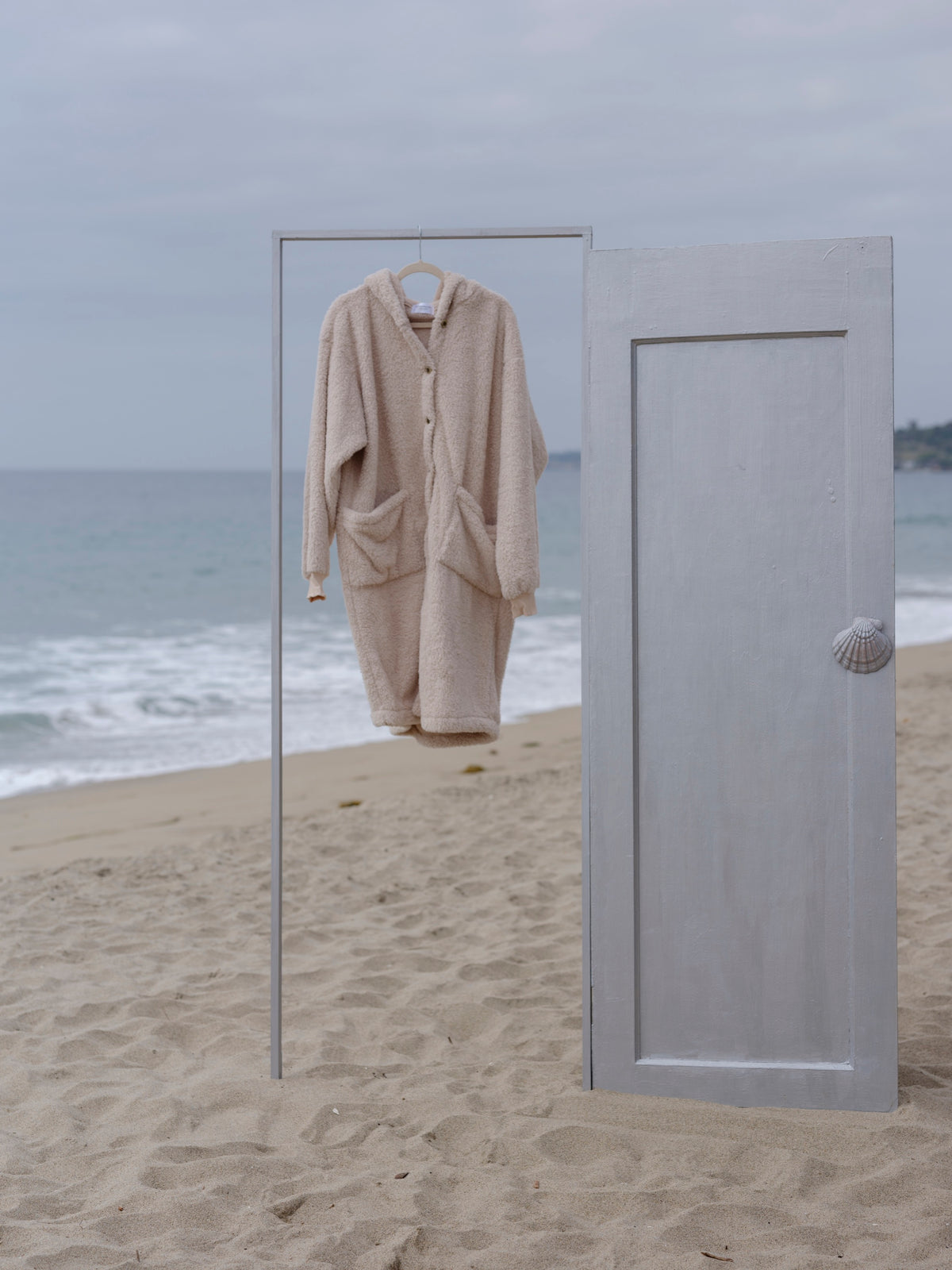 Sheep Long Papàsweater hanging from a clothing rack