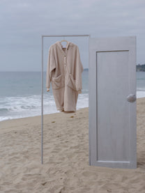 Sheep Long Papàsweater hanging from a clothing rack